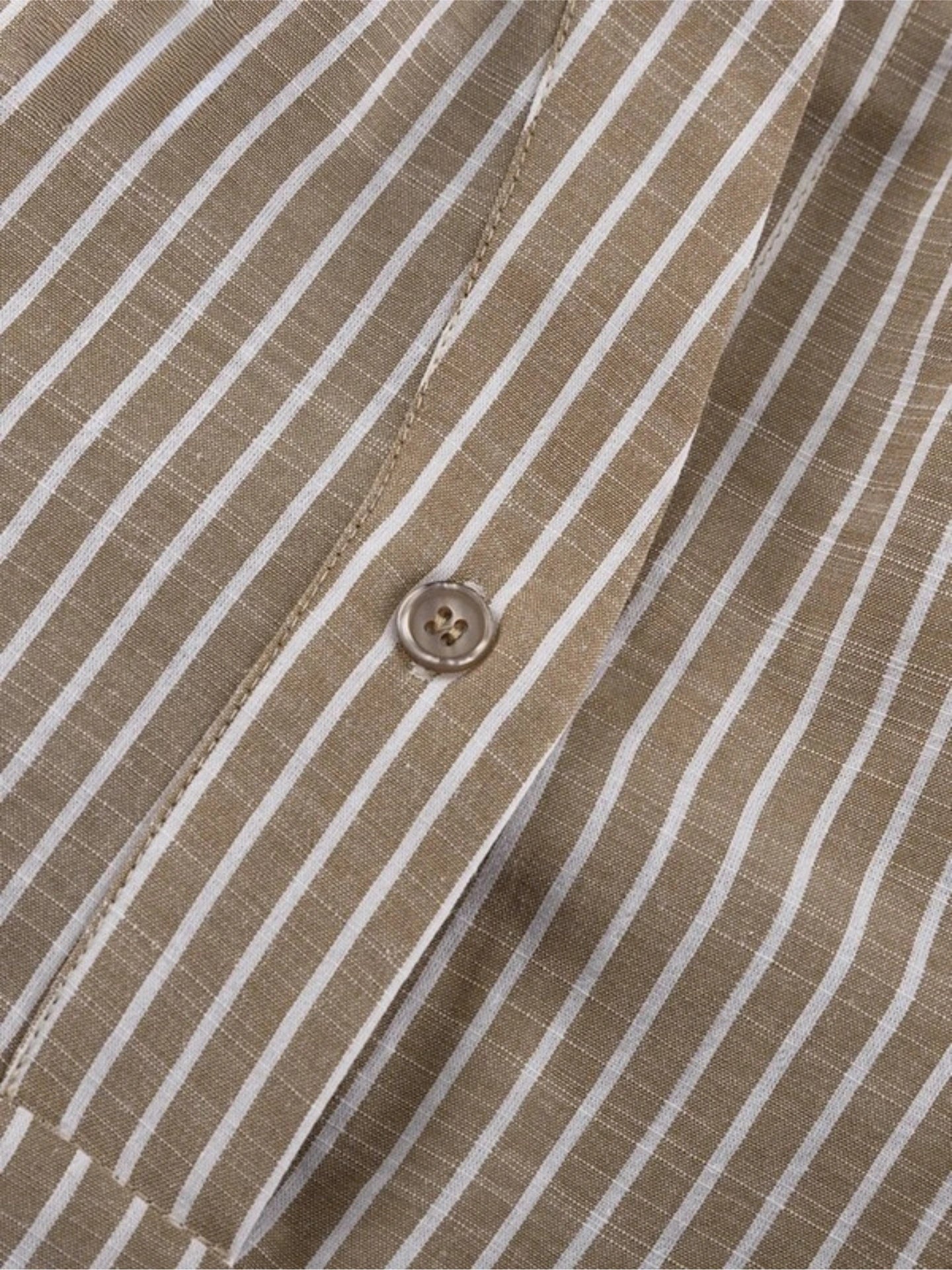 Close-up of a brown and white striped shirt with a button