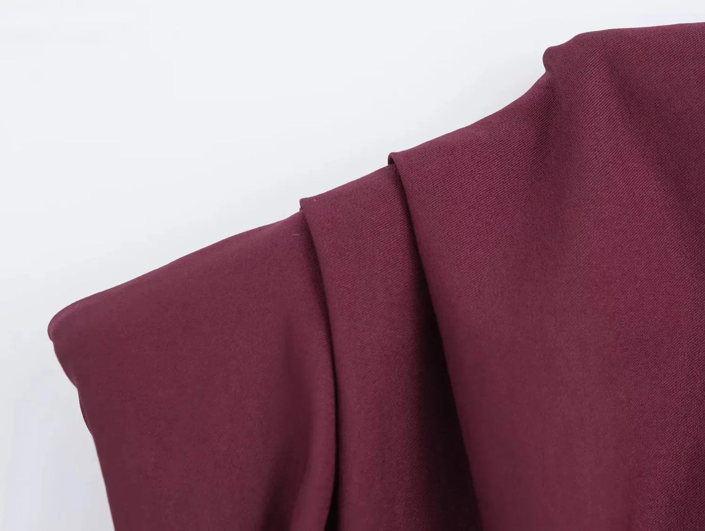 close up shoulder of wine red top on a white background