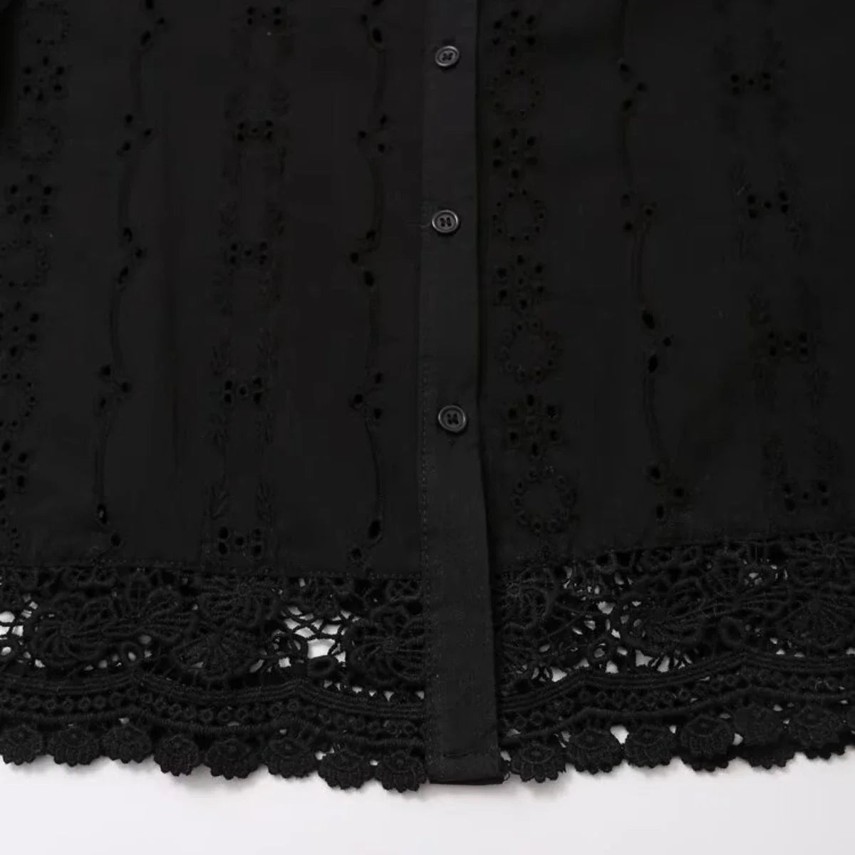 Detail of floral lace trim and button placket on the black Celeste Shirt by Noir by Lina, highlighting embroidery and texture