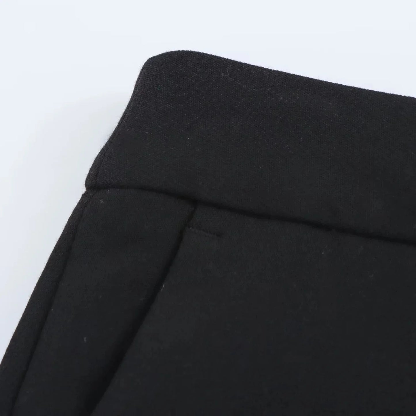 Detail of waistband and slanted pocket on black slim flared trousers from the Valencia Power Suit by Noir by Lina