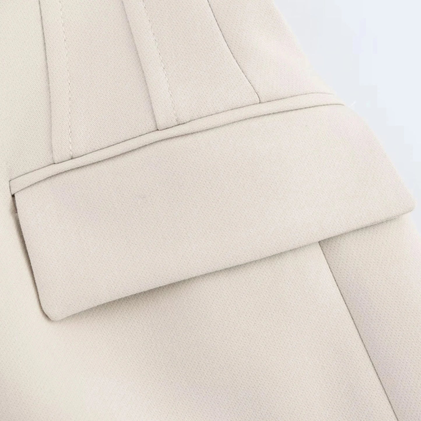 Close-up of structured flap pocket and stitching on white Valencia Power Suit blazer by Noir by Lina