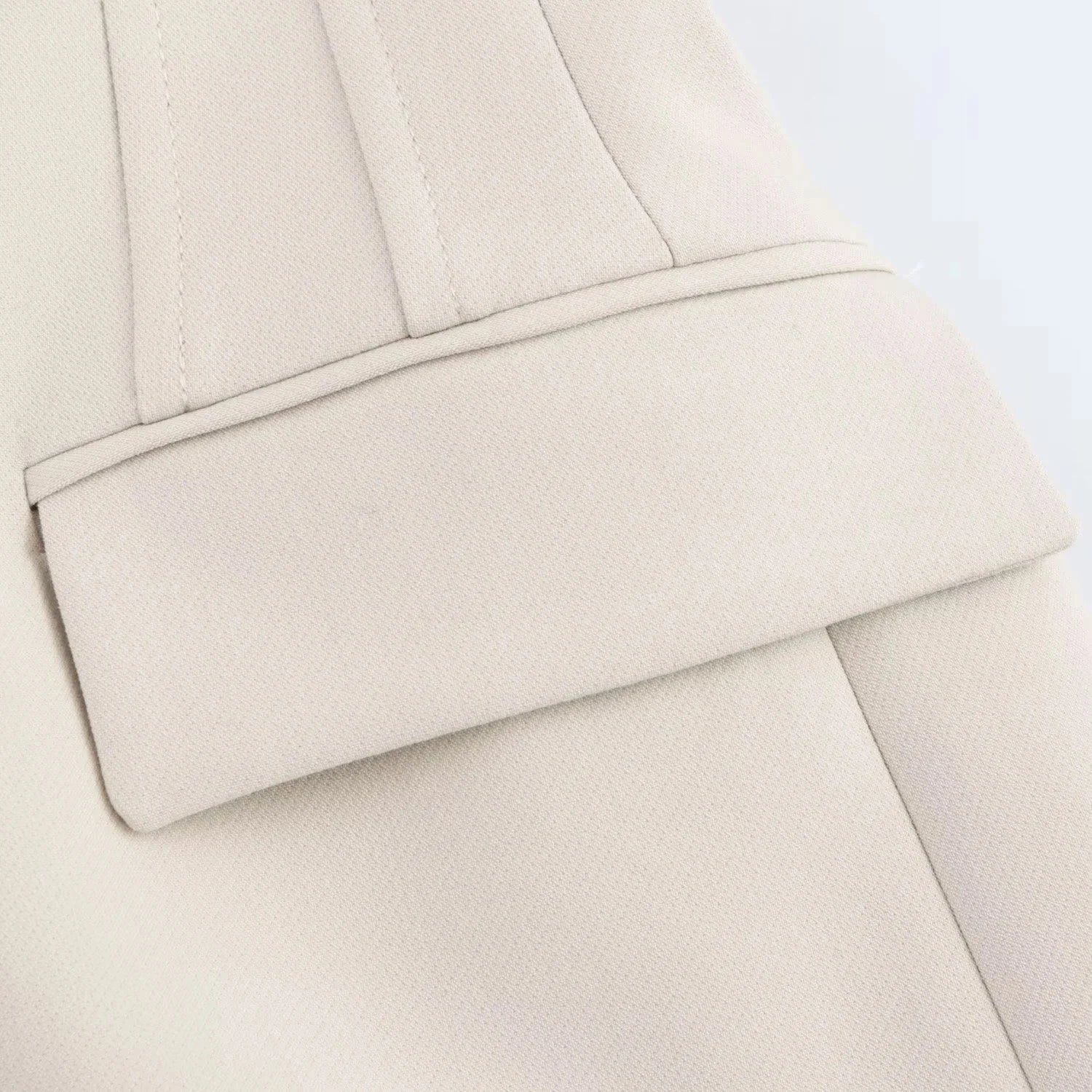 Close-up of structured flap pocket and stitching on white Valencia Power Suit blazer by Noir by Lina